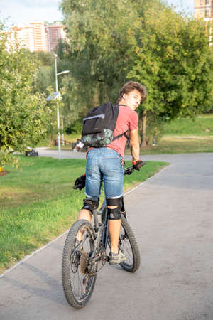 Russia, Moscow, September 2020. A seventeen-year-old boy rides a Bicycle in a public Park.のeditorial素材