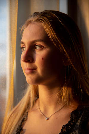 Portrait of a beautiful girl by the window.の写真素材