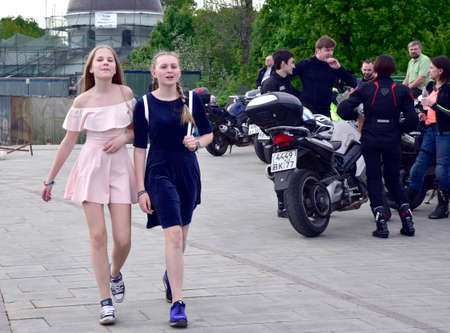 Russia, Moscow, may 2018. Teenage girls walk past a group of motorcyclists on the Sparrow hills.のeditorial素材