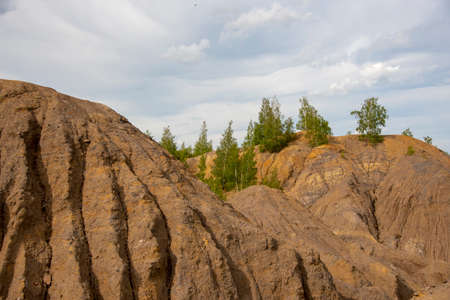 Relief clay mountains under a cloudy sky.の写真素材