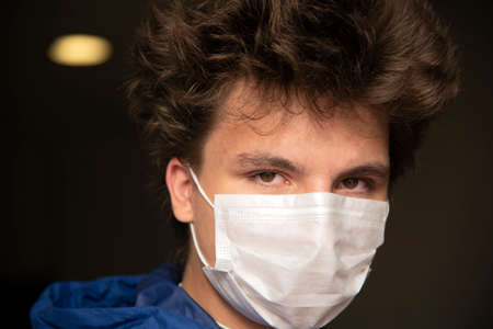 Portrait of a teenage boy in a protective mask on an abstract background.の写真素材