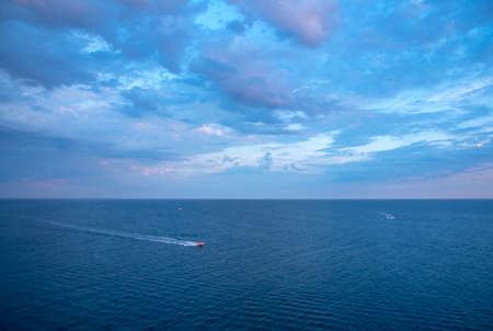 Full frame bright blue sea and sky as a backdrop. Boats float on the sea.Natural background, copy space for text.の写真素材