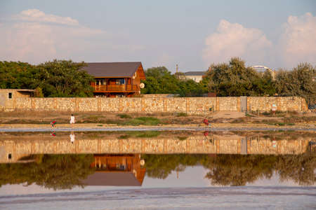 Yellow house on the lake shore, reflected in the water.のeditorial素材