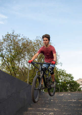Russia, Moscow, September 2020. A teenager with a Bicycle stands at the top of the stairs at the glass building.のeditorial素材