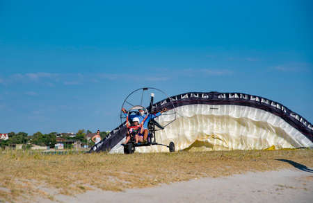 Crimea, Cape Tarkhankut, August 2020. A girl in a helmet and a man in a mask take off on a...