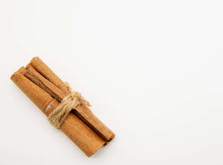 Cinnamon sticks tied with a jute cord on a white background.の写真素材
