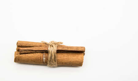 Cinnamon sticks tied with a jute cord on a white background.の写真素材