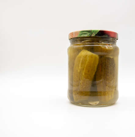 Transparent glass jar with pickled cucumbers on a white background.の写真素材