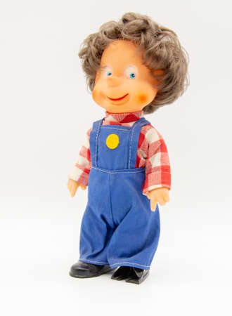 Retro doll in work overalls with gray hair on a white background.の写真素材