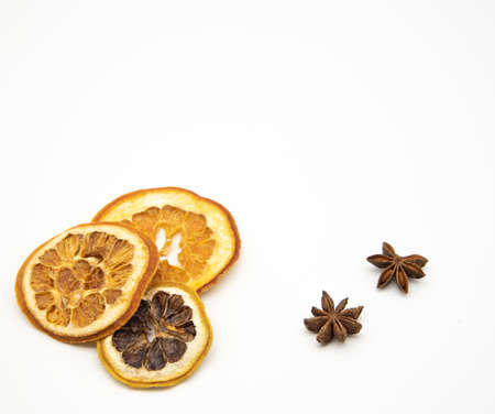 A few slices of dried orange and star anise on a white background. Aromatic spices for drinks and pastries.の写真素材