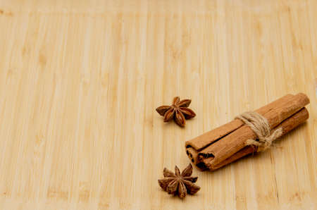 Cinnamon sticks and a few star anise on a wooden background.の写真素材