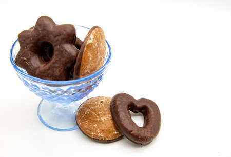 On a white background, a blue glass vase with gingerbread cakes of different sizes and shapes.の写真素材