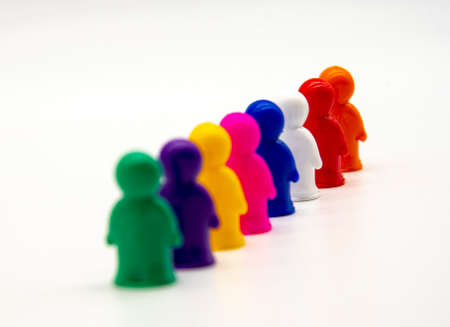 Miniature plastic toy figures stand in formation on a white background.の写真素材
