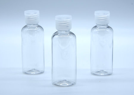 Transparent empty cosmetic bottles and jars on a soft blue background.の写真素材