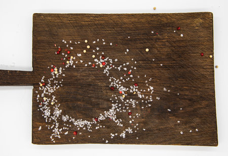 Top view of a cutting Board sprinkled with salt and pepper.The spices form a circle. The background for the packaging.の写真素材
