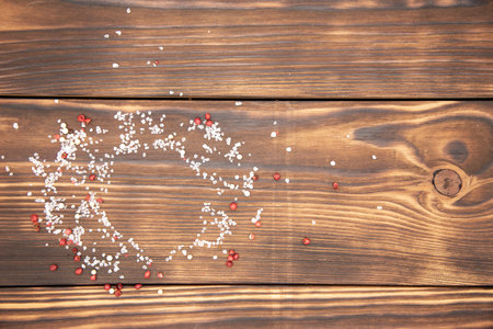 Top view of a cutting Board sprinkled with salt and pepper. The spices form a circle. The background for the packaging.の写真素材