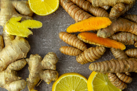 Fresh turmeric root, ginger, oranges and lemon on a gray slate background. The concept of a healthy lifestyle, and food additives.の写真素材