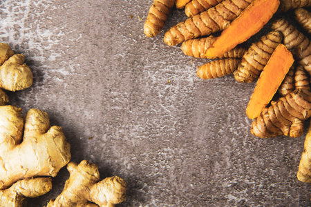 Fresh turmeric and ginger root on grey slate background. Copy space for text, top view.の写真素材