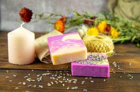 Natural handmade skincare. Handmade natural soap, candles and flowers on the dark wooden countertop.の写真素材