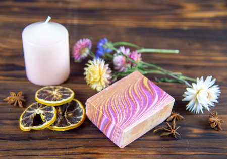 Natural handmade skincare. Handmade natural soap, candles and flowers on the dark wooden countertop.の写真素材