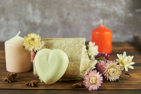Natural handmade skincare. Handmade natural soap, candles and flowers on the dark wooden countertop.の写真素材