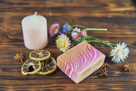 Natural handmade skincare. Handmade natural soap, candles and flowers on the dark wooden countertop.の写真素材