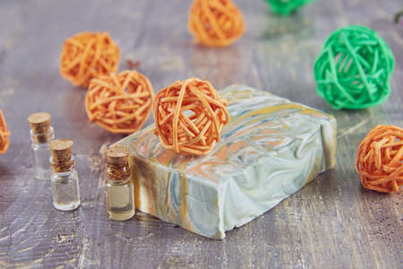 Organic scented handmade soap on a wooden gray countertop surrounded by decor. The concept of a...