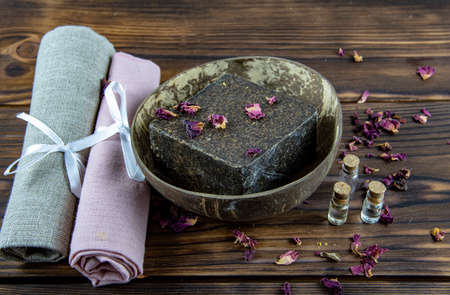 Organic aromatic handmade soap in a coconut bowl and personal care items made of natural materials on a wooden countertop. The concept of a healthy lifestyle.の写真素材
