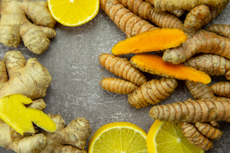 Fresh turmeric root, ginger, oranges and lemon on a gray slate background. The concept of a healthy lifestyle, and food additives.の写真素材