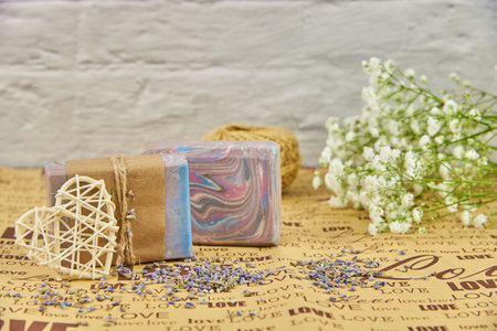 Colorful handmade soap on wrapping paper with the inscription love and white flowers of gypsophila.の写真素材