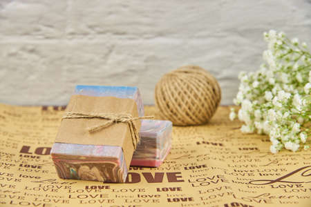 Colorful handmade soap on wrapping paper with the inscription love and white flowers of gypsophila.の写真素材