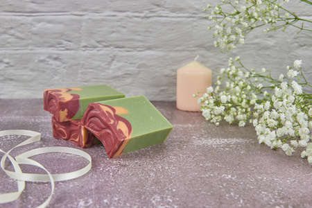 Bright, fragrant handmade soap and delicate gypsophila flowers on the gray countertop. Copy space for text, design.の写真素材