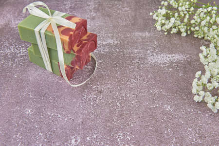 Bright, fragrant handmade soap and delicate gypsophila flowers on the gray countertop. Copy space for text, design.の写真素材