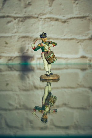 One tin soldier stands on the glass surface, reflecting in it.の写真素材