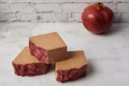 Bright handmade soap and garnet on a gray countertop against a brick wall. hobby to make a beautiful hand made natural soap from environmental products.の写真素材
