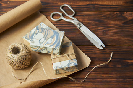 Fragrant colorful handmade soap, scissors and rope, lie on the packaging paper. Healthy lifestyle, online sales.の写真素材