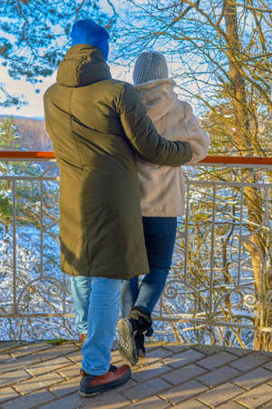 Russia, Dorokhovo village, December 2020. A couple in love, a man and a woman, stand with their backs to the camera against the backdrop of a winter landscape on a sunny day.のeditorial素材