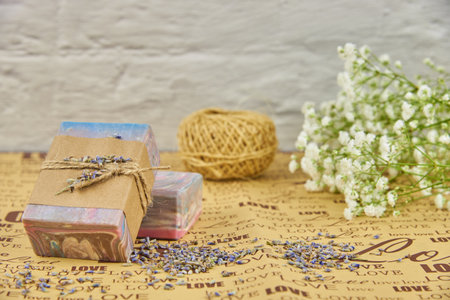 Colorful handmade soap on wrapping paper with the inscription love and white flowers of gypsophila.の写真素材