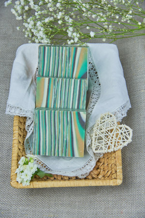 Fragrant striped handmade soap in a wicker basket on a white napkin. Personal hygiene items, spa product.の写真素材