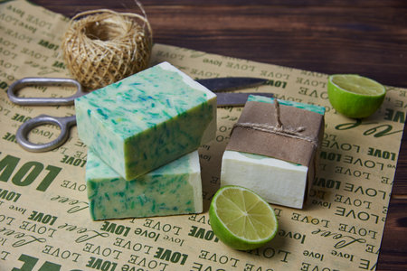 Fragrant handmade soap, scissors and rope, lemon and lime, lie on the packaging paper with the inscription love. Healthy lifestyle, online sales.の写真素材