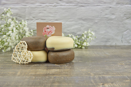 Handmade soap in the shape of a heart decorated with flowers on a wooden countertop. The concept of a healthy lifestyle. Product advertisingの写真素材