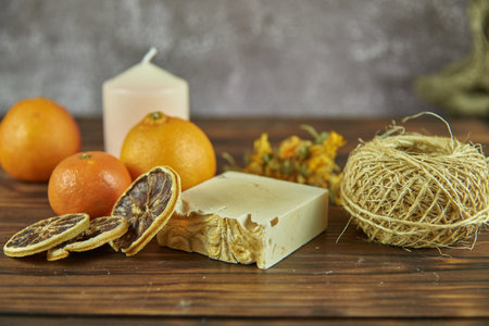 Handmade natural soap and various decorative items on the dark wooden countertop.の写真素材
