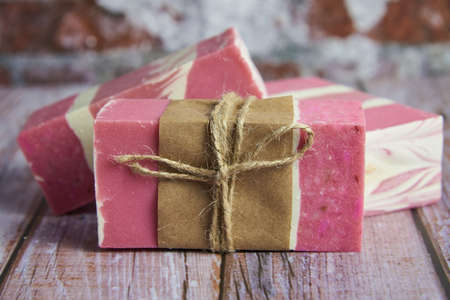 Three pieces of fragrant organic handmade soap on a wooden countertop.の写真素材