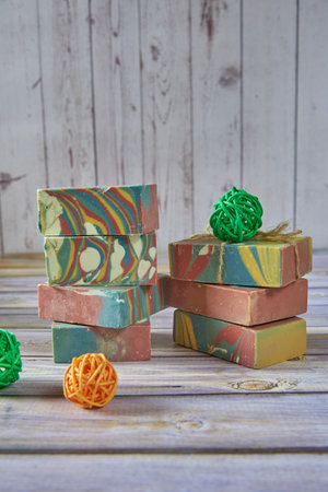 Several pieces of multicolored handmade organic soap and various decorations on a light gray background.の写真素材