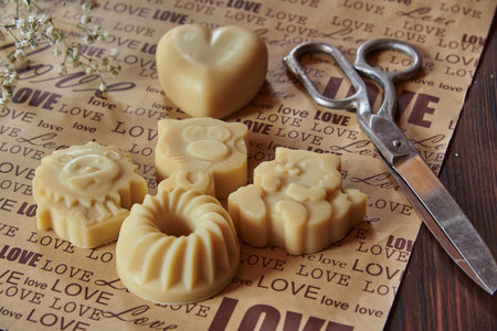 Scented organic baby soap handmade in the shape of animals and vintage large scissors on packaging paper with the inscription love.の写真素材