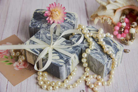 Gray-white handmade soap made from natural ingredients is decorated with pearl beads. Personal hygiene items, healthy lifestyle.の写真素材