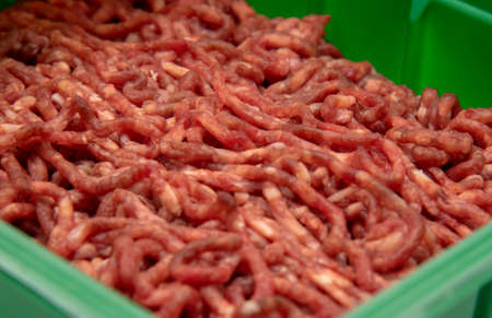 Full frame fresh raw minced meat as a backdrop.