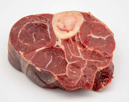 A piece of raw meat with a bone on a white background.の写真素材