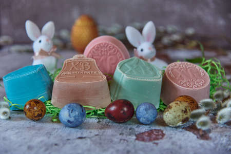 Delicate, fragrant handmade Easter soap and a variety of Easter decor on the textured countertop.の写真素材