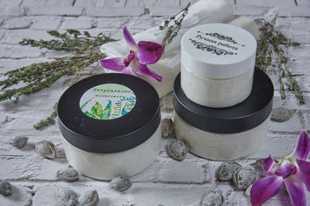 Natural handmade cosmetic cream jar and dried aromatic herbs and apricot pits ,. Bio organic cosmetics, aromatherapy concept.On one jar is written natural ingredients, on the other-handmade.の写真素材